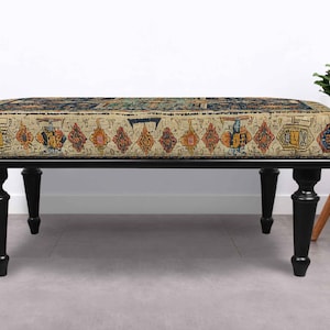 May include: A rectangular bench with a patterned cushion in beige, orange, and blue hues. The bench has a black frame and four turned legs. The cushion design has a vintage, rug-like appearance.