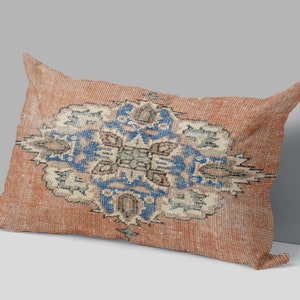 May include: A rectangular pillow with a red and orange background and a blue and white floral pattern.