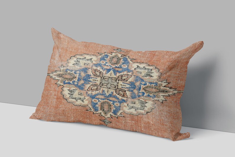 May include: A rectangular pillow with a red and orange background and a blue and white floral pattern.