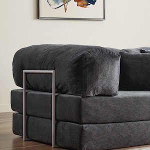 Puede incluir: Un sof&aacute; modular de pana gris antracita con una estructura met&aacute;lica minimalista. El sof&aacute; presenta un dise&ntilde;o apilado con secciones gruesas y acolchadas y un reposabrazos redondeado. La tela de pana tiene una textura acanalada vertical.
