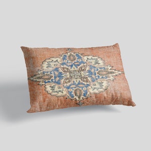 May include: A rectangular pillow with a red, blue, and white patterned design. The pattern is a traditional rug design with a central medallion and floral motifs.