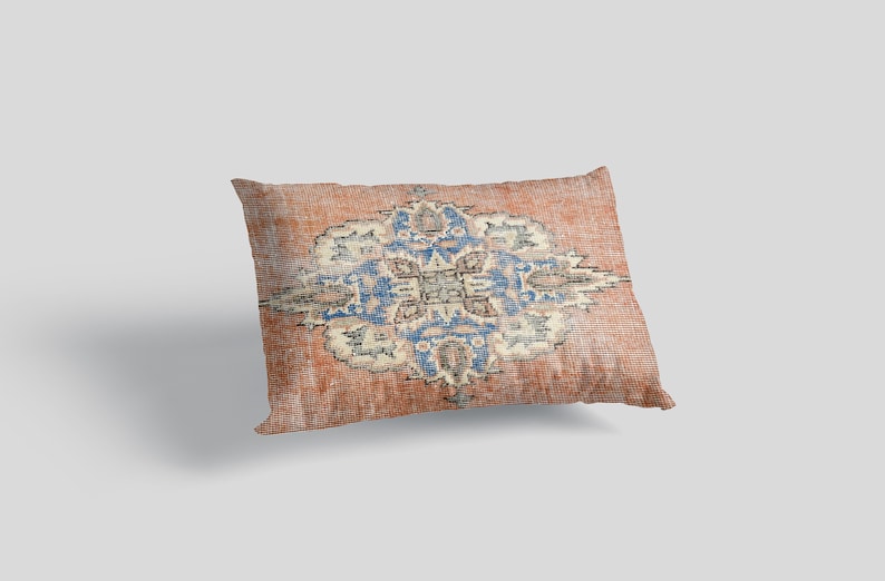 May include: A rectangular pillow with a red, blue, and white patterned design. The pattern is a traditional rug design with a central medallion and floral motifs.