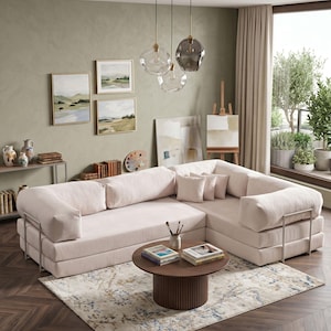 Puede incluir: Sal&oacute;n moderno con un sof&aacute; seccional rosa claro, una mesa de centro redonda de madera y una alfombra estampada. La habitaci&oacute;n est&aacute; decorada con pinturas de paisajes, jarrones decorativos y l&aacute;mparas colgantes de cristal.