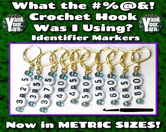 May include: Set of eight gold crochet hook size markers with white and blue beads. The markers are numbered 3.25, 3.5, 3.75, 4.0, 4.5, 5.0, 6.0, and 6.5. The text "Now in METRIC SIZES!" is at the bottom of the image.