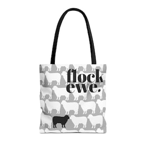 Puede incluir: Una bolsa de tela blanca con fondo gris y un patrón de ovejas blancas. La bolsa tiene asas negras y el texto "flock ewe." impreso en negro. Una oveja negra está en el centro del patrón.
