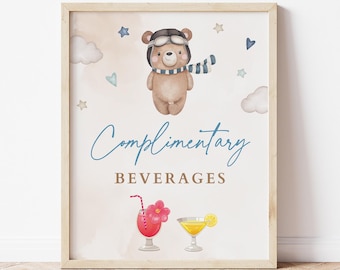 May include: A framed print featuring a watercolor illustration. A teddy bear wearing aviator goggles and a scarf is above the words "Complimentary Beverages." Below are illustrations of two cocktails. The background has clouds, stars, and hearts.