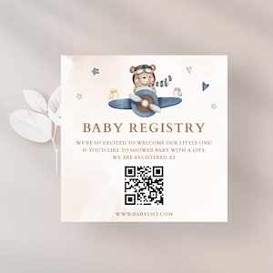 Könnte beinhalten: Quadratische Baby-Registrierungskarte mit einer Aquarellillustration eines Teddybären mit Pilotenmütze und Schal auf einem blauen Flugzeug. Die Karte enthält den Text "BABY REGISTRY" und einen QR-Code mit der Website www.babylist.com.