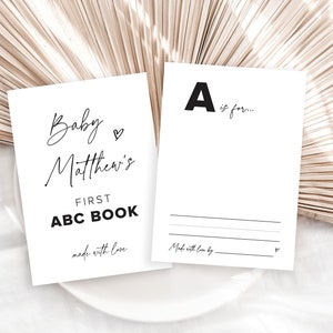 May include: Two white cards with black text. The first card says "Baby Matthew's First ABC Book made with love". The second card says "A is for... Made with love by".