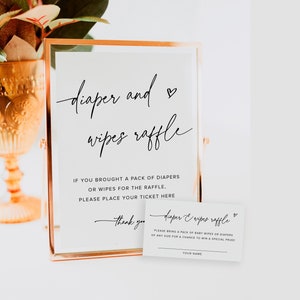 Puede incluir: Un cartel blanco con texto negro que dice "diaper and wipes raffle". El cartel está en un marco dorado y está sentado en una mesa blanca. El cartel dice "Si trajiste un paquete de pañales o toallitas para la rifa, por favor coloca tu boleto aquí. Gracias." Hay una tarjeta blanca más pequeña con texto negro que dice "diaper & wipes raffle. Por favor trae un paquete de toallitas para bebé o pañales de cualquier tamaño para tener la oportunidad de ganar un premio especial! Tu nombre."