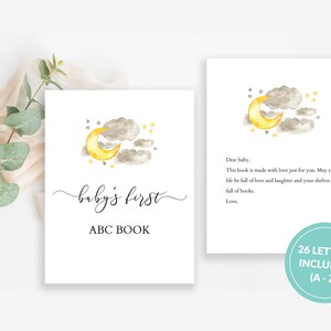 May include: A watercolour illustration of a yellow crescent moon and grey clouds with stars on a white background. The text "baby's first ABC BOOK" is written in black cursive script below the illustration. A separate card with the same illustration and text "Dear baby, This book is made with love just for you. May your life be full of love and laughter and your shelves be full of books. Love," is also shown. A blue circle with the text "26 LETTERS INCLUDED (A-Z)" is in the bottom right corner.