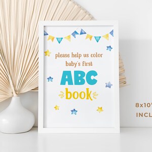 May include: White frame with a printable sign that says "Please help us color baby's first ABC book". The sign has a blue and yellow color scheme with stars and bunting. The sign is 8x10 inches.