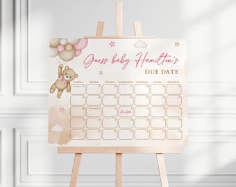 May include: A baby shower sign on a wooden easel. The sign features a calendar grid with the text "Guess baby Hamilton's DUE DATE" in pink script. A teddy bear with balloons is in the upper left corner. The background has soft pink and beige watercolor washes.