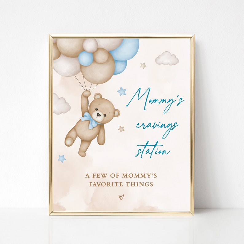 Puede incluir: Impresi&oacute;n enmarcada con borde dorado. Un oso de peluche con lazo azul sostiene globos marrones, blancos y azules. El texto dice "Mommy's cravings station" y "A few of mommy's favorite things". El fondo es beige.