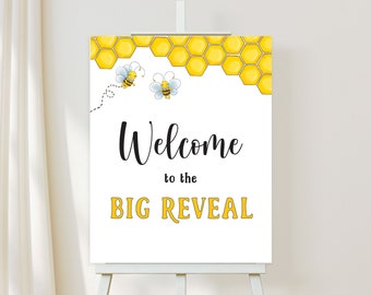 May include: White sign with black text that says "Welcome to the BIG REVEAL". The sign has a yellow honeycomb pattern at the top with two cartoon bees.