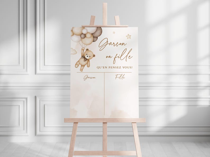 May include: A gender reveal party sign featuring a teddy bear holding balloons. The sign reads "Gar&ccedil;on ou Fille? Qu'en pensez vous?" with spaces for guests to write "Gar&ccedil;on" or "Fille".