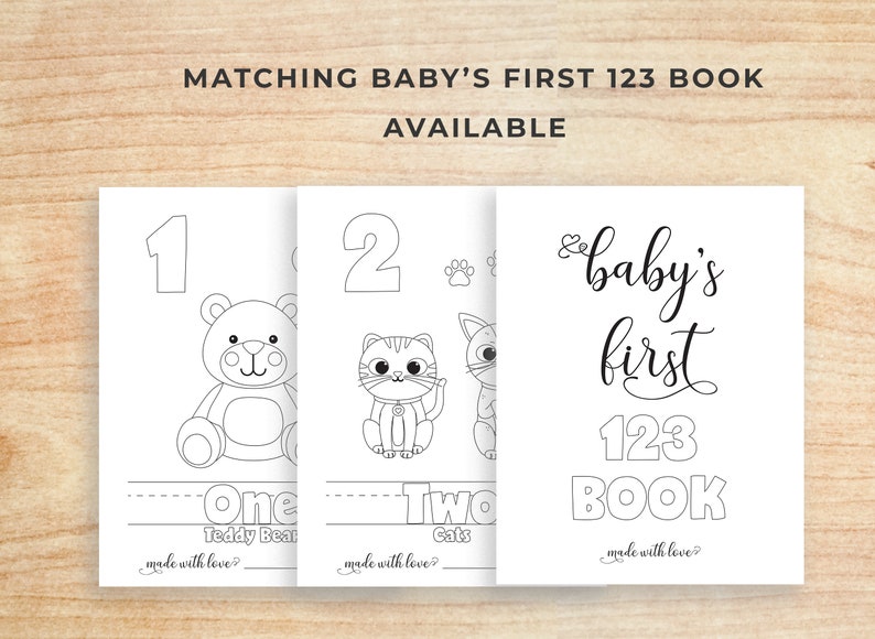 K&ouml;nnte beinhalten: Schwarz-wei&szlig;e druckbare Seiten f&uuml;r ein erstes 123-Buch f&uuml;r Babys. Die Seiten zeigen die Zahlen 1 und 2 mit entsprechenden Illustrationen eines Teddyb&auml;ren und zweier Katzen. Die Titelseite lautet "baby's first 123 book".