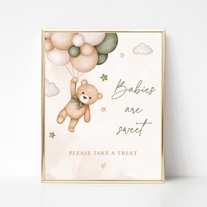 May include: A printable baby shower sign with a teddy bear holding onto green and beige balloons. The sign says "Babies are sweet" and "Please take a treat".
