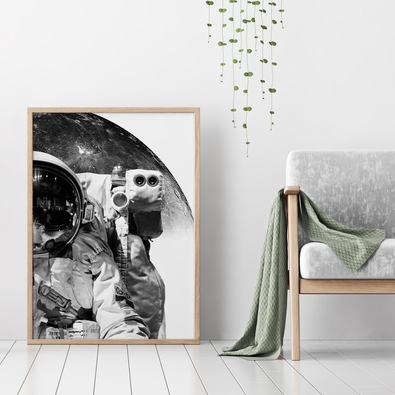 May include: A black and white photograph of an astronaut in a spacesuit standing in front of the moon. The astronaut's helmet reflects the moon's surface.