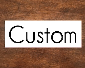 May include: White sign with the word "Custom" in black lettering.