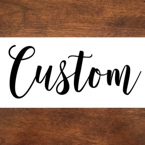 May include: White sign with the word "Custom" written in black cursive script.