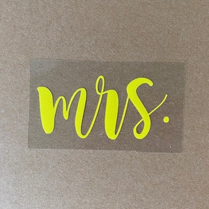 Pu&ograve; includere: Un adesivo in vinile giallo con la parola "mrs." scritta in corsivo.