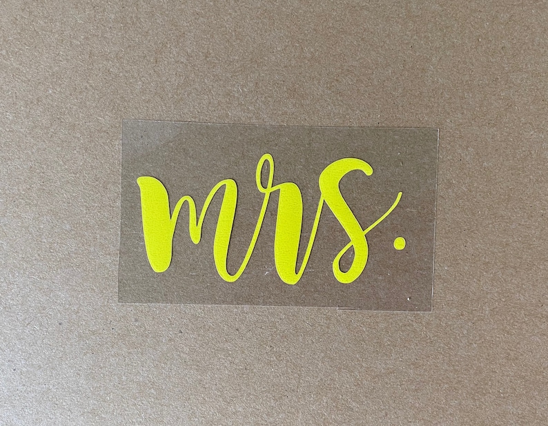 Pu&ograve; includere: Un adesivo in vinile giallo con la parola "mrs." scritta in corsivo.