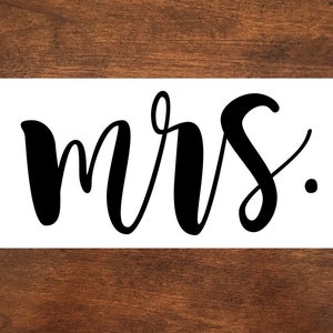 May include: White background with black cursive lettering that reads "mrs."