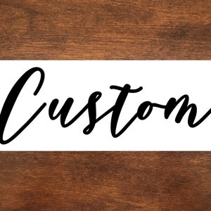 May include: White sign with the word "Custom" written in black cursive script.