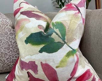 May include: A cream-colored throw pillow with a watercolor design of pink, green, and white leaves.