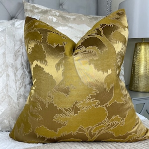 May include: A gold throw pillow with a raised floral pattern. The pillow is made of a soft, luxurious fabric and has a subtle sheen.