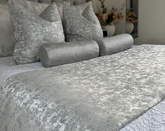 Könnte beinhalten: Ein silbernes und weißes Bett mit einem strukturierten Bettbezug und mehreren Dekokissen. Die Kissen sind in einer Reihe am Kopfende des Bettes angeordnet.