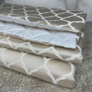 May include: A stack of four beige fabric squares with a white geometric pattern. The fabric is soft and luxurious, and the pattern is subtle and elegant.