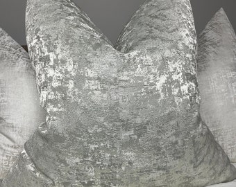 May include: Two decorative throw pillows with a silver and gray abstract pattern. The pillows are made of a soft, textured fabric.