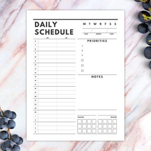 May include: A black and white daily schedule planner with sections for daily tasks, priorities, notes, and trackers. The planner has a simple design with a black header and a white background.