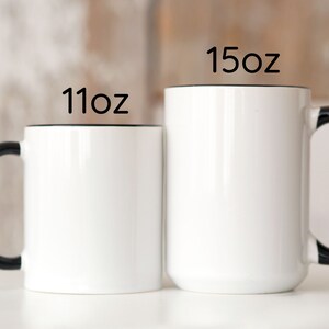 two black and white coffee mugs sitting next to each other