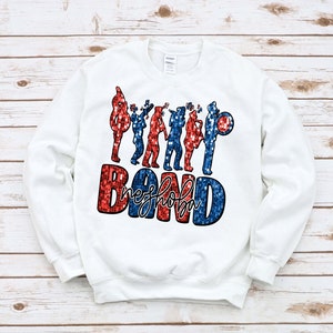 May include: White sweatshirt with a red, white, and blue glitter design of marching band members and the text "High School Band".