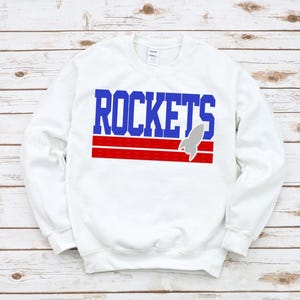 May include: White sweatshirt with a blue and red graphic that says "ROCKETS" with a gray rocket ship.