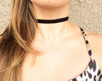 Puede incluir: Un collar gargantilla de terciopelo negro. La gargantilla es una simple banda de terciopelo negro, que se lleva alrededor del cuello. La modelo lleva un top con estampado de leopardo.