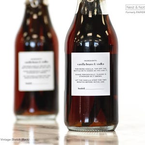 May include: Two glass bottles filled with a dark liquid, likely a vanilla extract or similar product. Each bottle has a white label with black text detailing ingredients and instructions. The text on the label reads "vanilla beans & vodka".