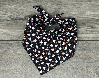 Puede incluir: Bandana negra con un patrón de fantasma blanco y calabaza naranja.