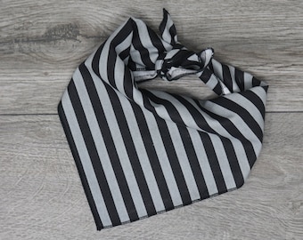 Puede incluir: Un pañuelo de bandana a rayas negras y grises con un diseño anudado. El pañuelo está hecho de una tela de algodón suave.
