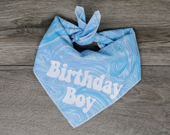 May include: Blue bandana with a white swirl pattern and the text "Birthday Boy" in white.