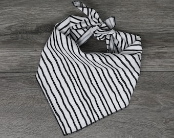 Puede incluir: Un pañuelo de bandana de rayas blancas y negras con un diseño anudado. El pañuelo está hecho de una tela de algodón suave y es perfecto para agregar un toque de estilo a cualquier atuendo.