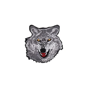 Könnte beinhalten: Ein grauer Wolf mit gelben Augen und einem roten Maul, das knurrt. Der Wolf ist auf einem Stoffpatch gestickt.
