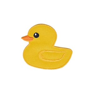 Könnte beinhalten: Eine gelbe Gummi-Ente mit schwarzen Augen und einem orangefarbenen Schnabel. Die Ente ist ein beliebtes Bade-Spielzeug für Kinder.