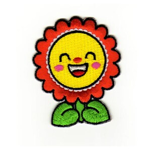 Könnte beinhalten: Gestickter Aufnäher mit einer lächelnden Sonnenblume mit gelbem Gesicht, roten Blütenblättern und grünen Blättern. Die Sonnenblume hat einen fröhlichen Ausdruck mit rosa Wangen und einer roten Nase. Der Aufnäher ist zum Aufbügeln oder Aufnähen auf Stoff gedacht.