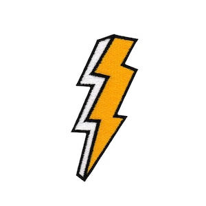 Könnte beinhalten: Gelber Blitz-förmiger Patch mit weißem Umriss. Der Patch ist aus Stoff und hat ein gesticktes Design.