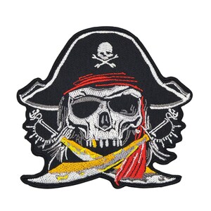 Könnte beinhalten: Gestickter Bügel-Patch mit einem weißen Totenkopf, der einen schwarzen Piratenhut mit rotem Bandana trägt. Der Totenkopf hat gekreuzte Schwerter dahinter.
