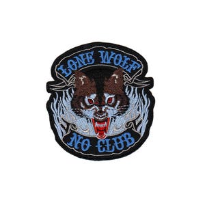 Könnte beinhalten: Gestickter Aufnäher mit schwarzem Hintergrund, der einen knurrenden Wolf mit roten Augen und einem blauen und weißen Flammenmuster zeigt. Der Text "Lone Wolf No Club" ist in Blau auf einem weißen Banner gestickt.