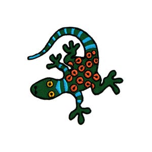 Könnte beinhalten: Grün und blauer gestickter Gecko mit orangefarbenen Flecken. Der Gecko ist im Cartoon-Stil mit großen Augen und einem langen Schwanz.
